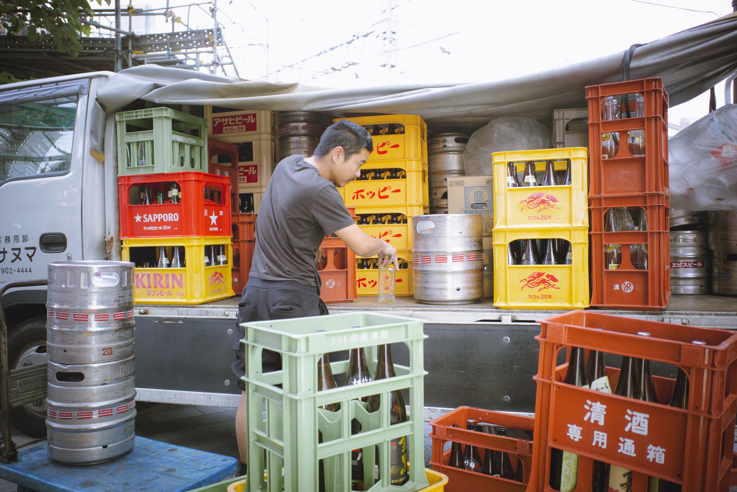 Delivery workers unloading alcohol for a restaurant in the evening.